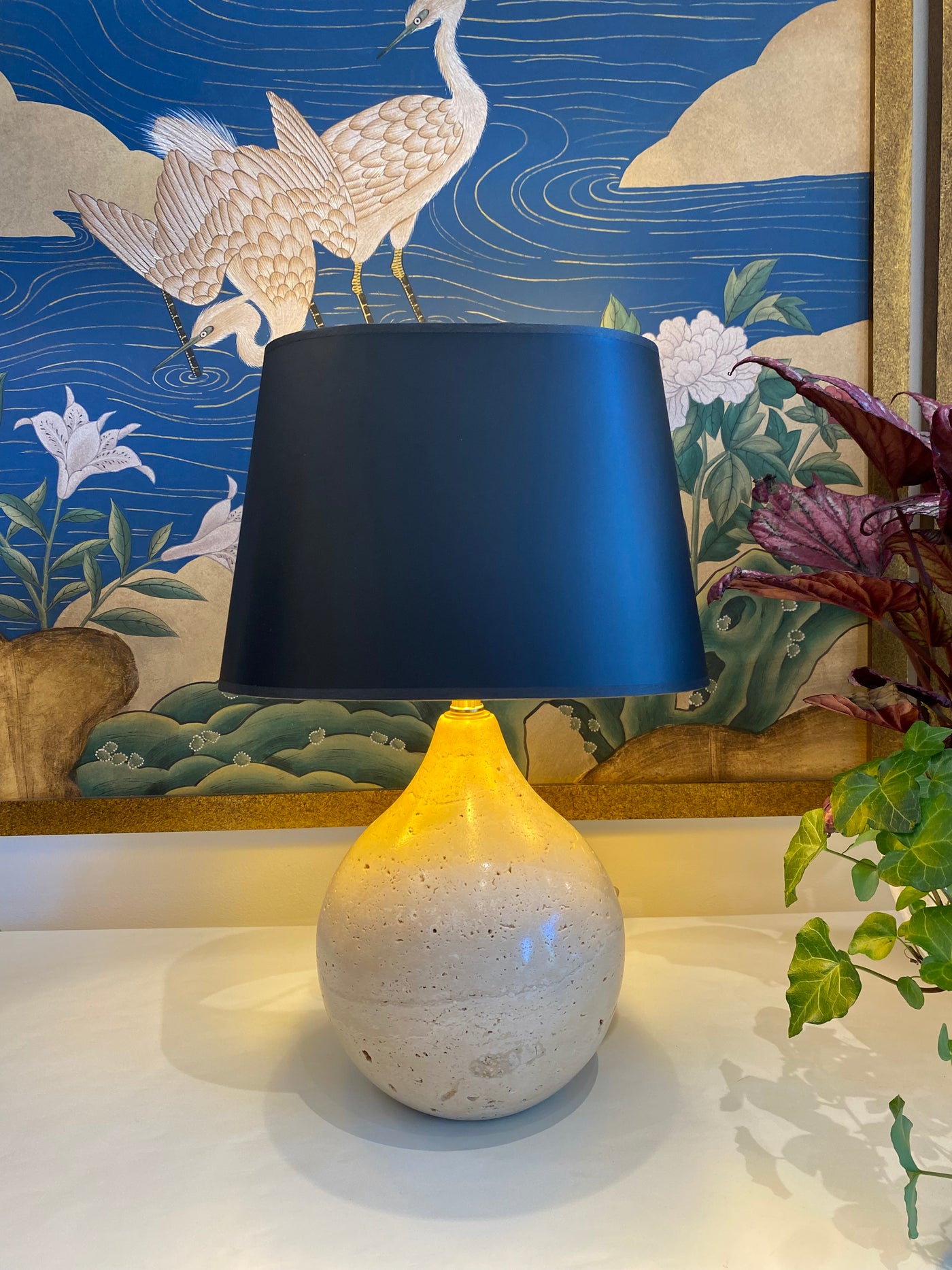 Black oval lampshade on a travertine lamp